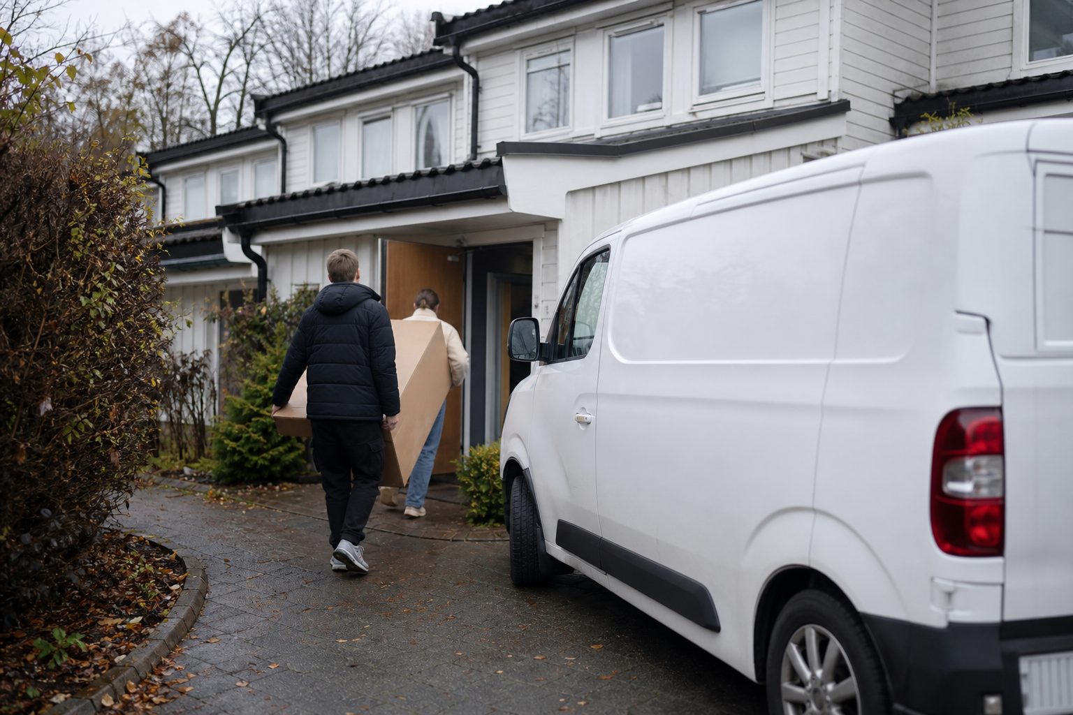 En hvit varebil uten logo står parkert utenfor et rekkehus i et norsk boligfelt.