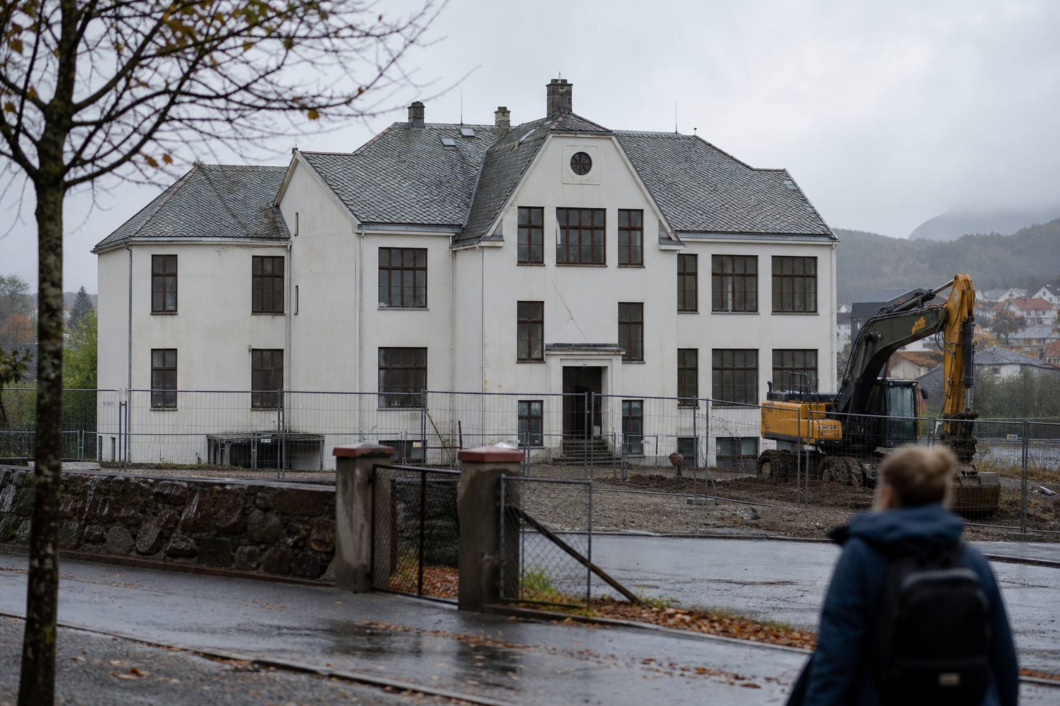 En eldre skolebygning i en liten norsk kystby en grå høstdag.